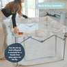 unfolding a grey portable baby playpen before use